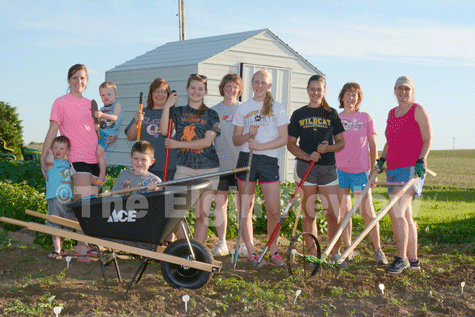 cedar-4h-garden-elgin-review-20150160-2 Posing in front of their new garden shed and with some of their new gardening tools are Cedar Creek club members and parents, l-r: Sawyer Veik, Heather Veik, Myles Veik, Landyn Veik (in wheel barrow), Lori Beckman, Erin Beckman, Diane Nelson, Amy Nelson, Grace Henn, Sandi Henn and Anne Meis. The club was able to purchase the new equipment with grant monies recently received from Farm Credit Services of America’s “Working Here Fund”. E-R photo